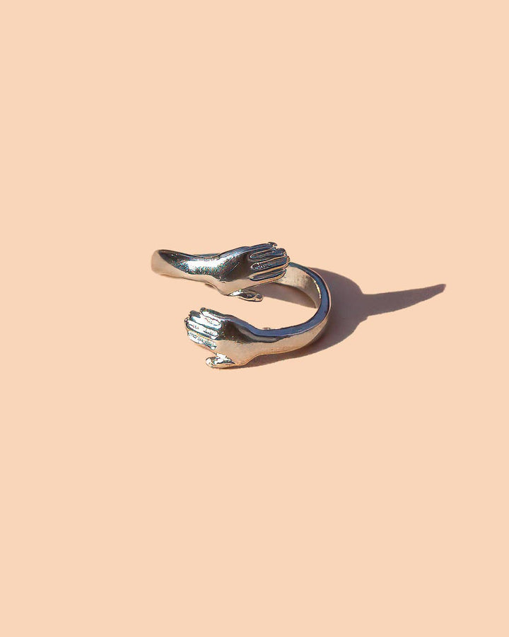 Silver hand-shaped Ring on a beige background winsome boutique chicago