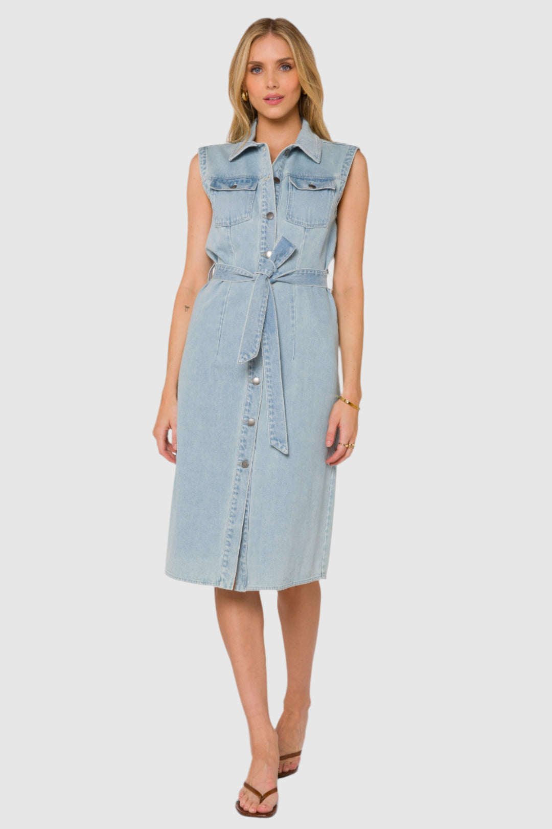 Woman wearing a light blue denim midi shirt dress on a white background