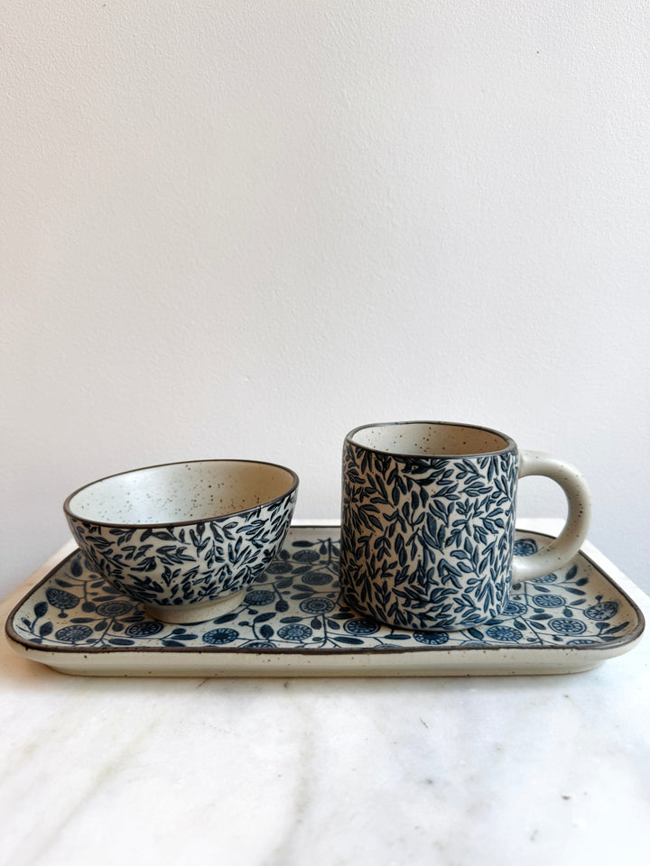 Ceramic cup, bowl, and tray with floral pattern on a white background