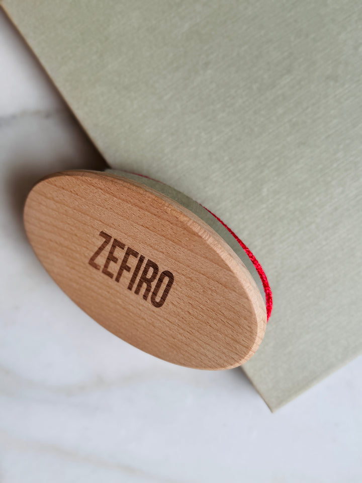 Wooden lint brush with 'Zefiro' branding on a light background