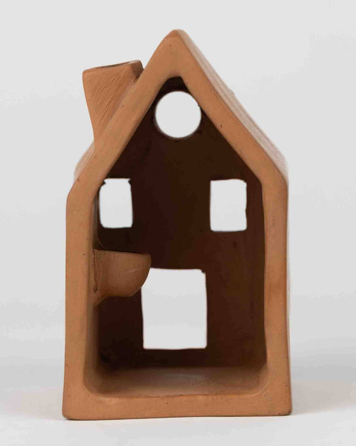 Terra cotta house-shaped object on a white background