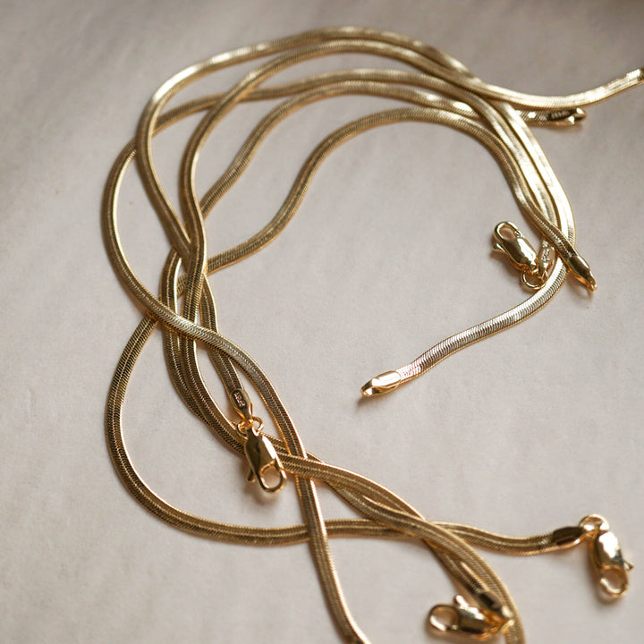 Gold bracelets on a light beige background