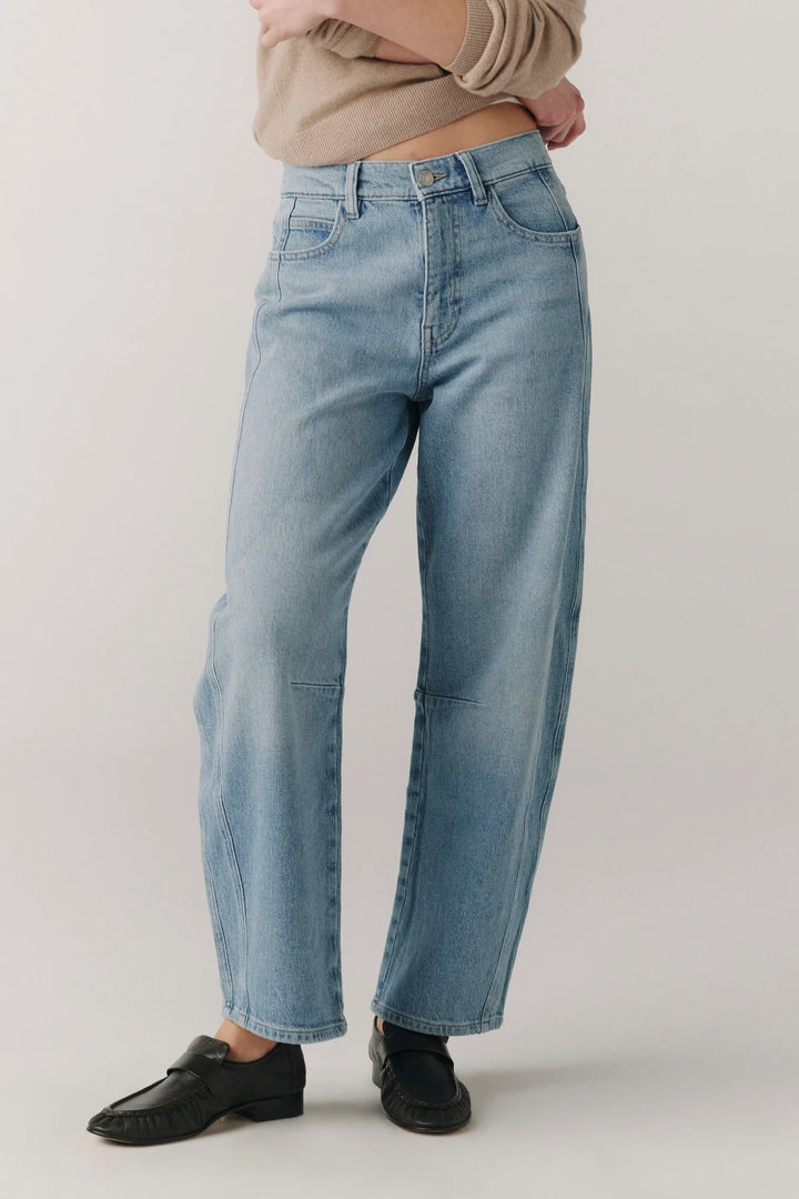 Person wearing light blue jeans on a plain background from Winsome clothing and goods a cute boutique in avondale chicago