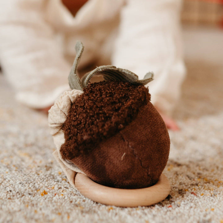 Brown felt acorn toy on a soft surface