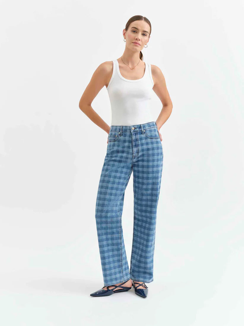 Woman wearing blue checkered pants and a white tank top on a white background