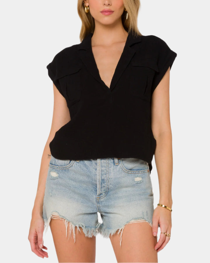 Woman wearing a black top and denim shorts on a white background