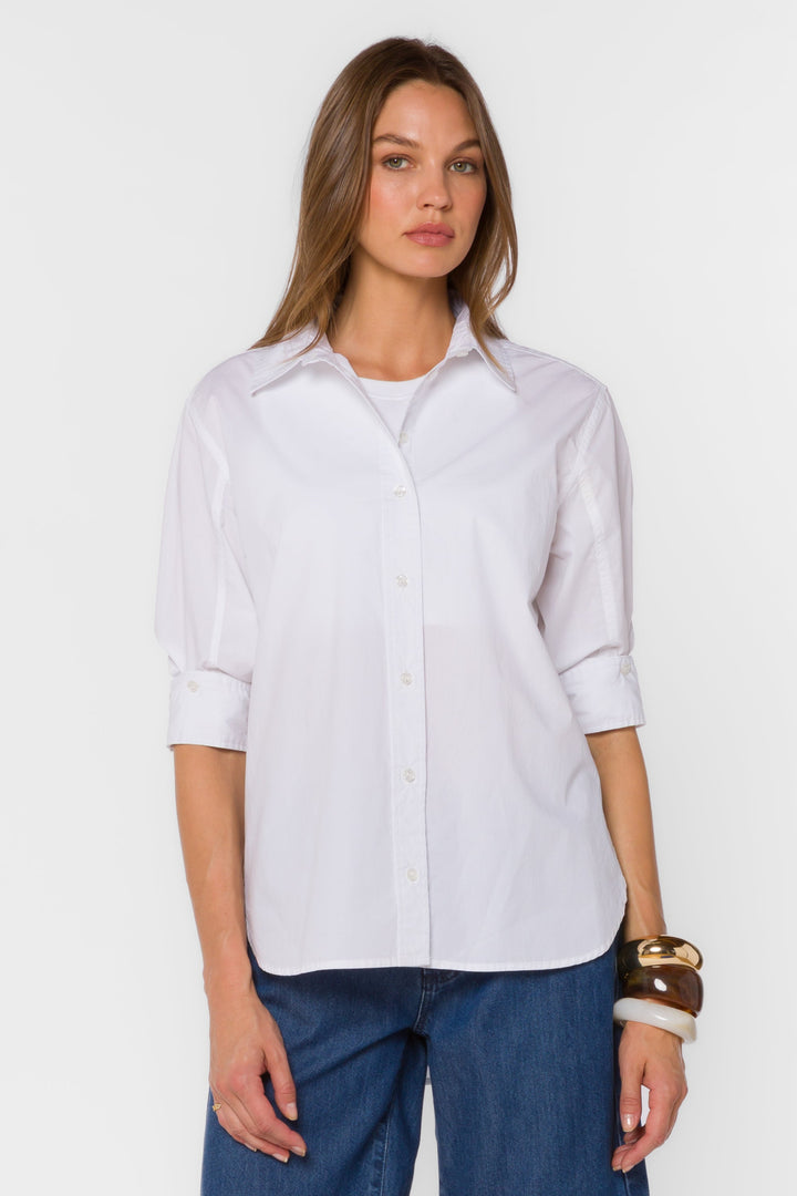 Woman wearing a white shirt and blue jeans on a white background