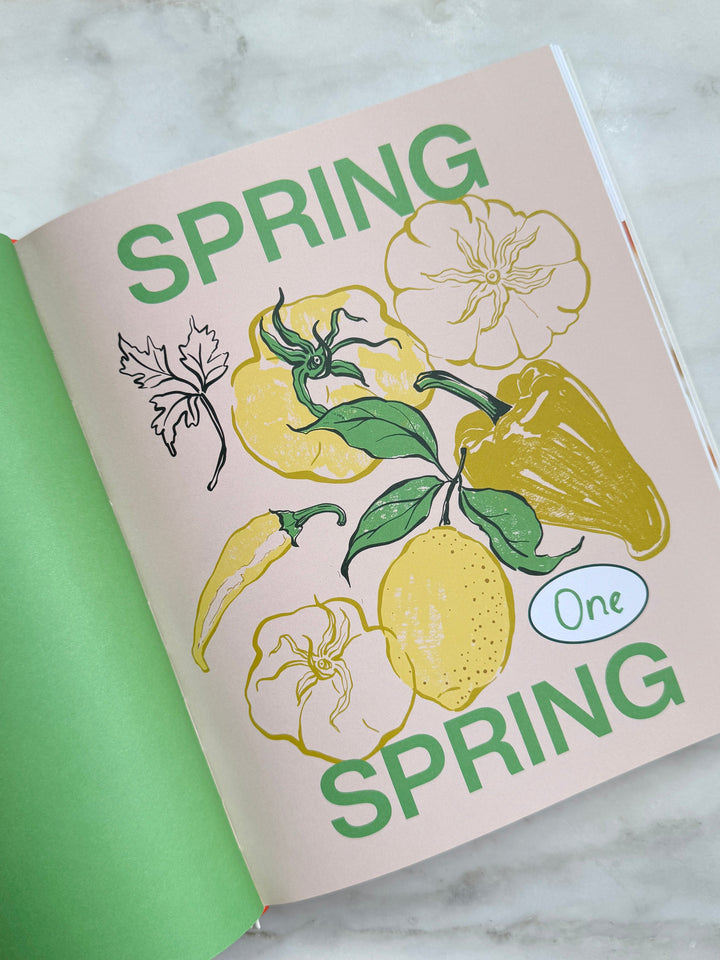 Book or notebook with 'Spring' and floral illustrations on a marble surface