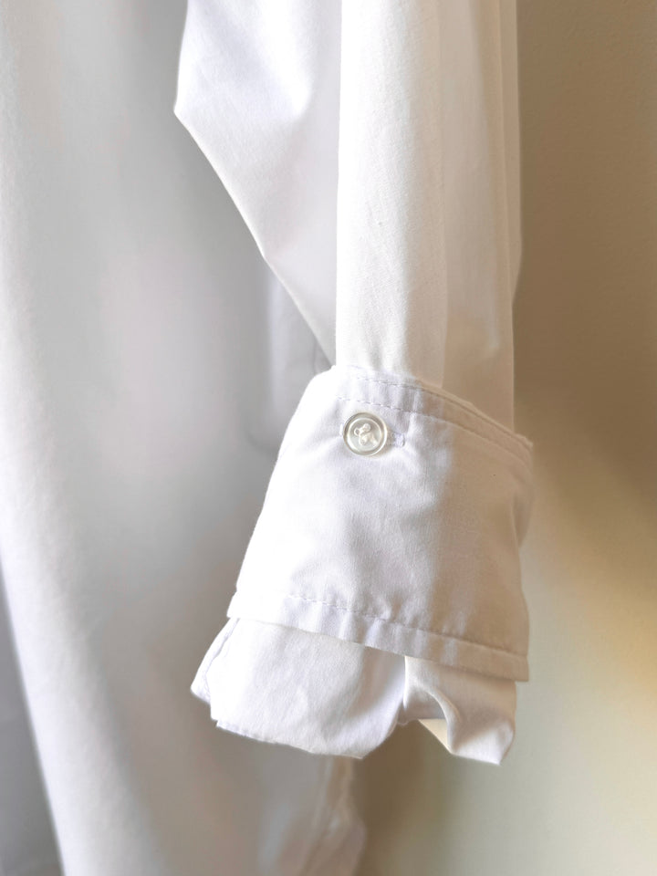 Close-up of a white shirt with a button on a light background