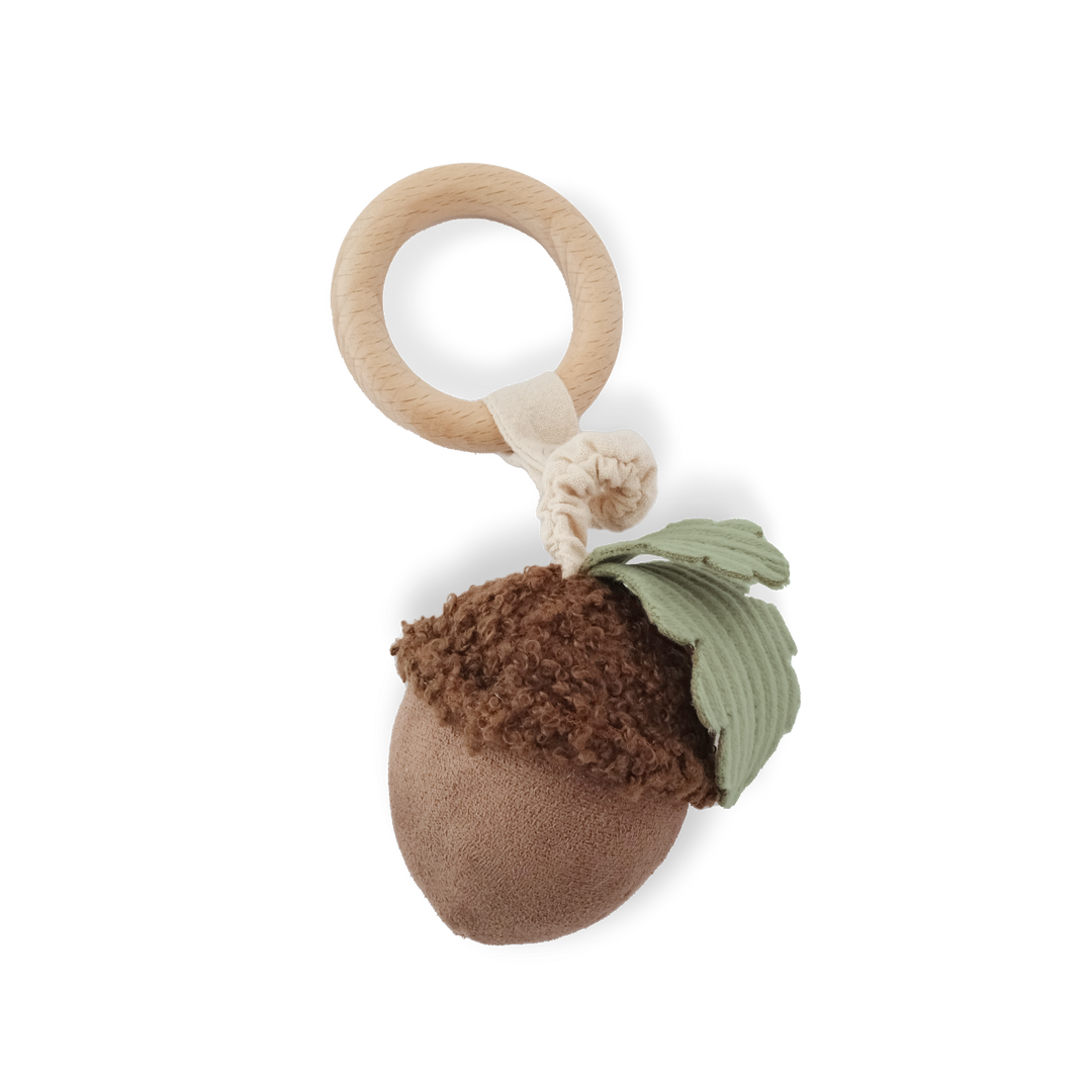 Baby rattle with acorn design and wooden ring on a white background