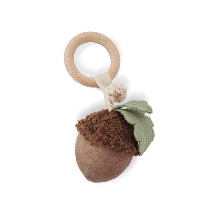 Baby rattle with acorn design and wooden ring on a white background