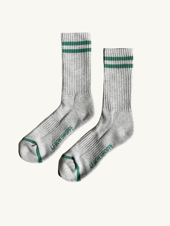 Pair of gray socks with green stripes and logo on a white background. Men's le bon shoppe socks chicago avondale winsome clothing & goods boutique