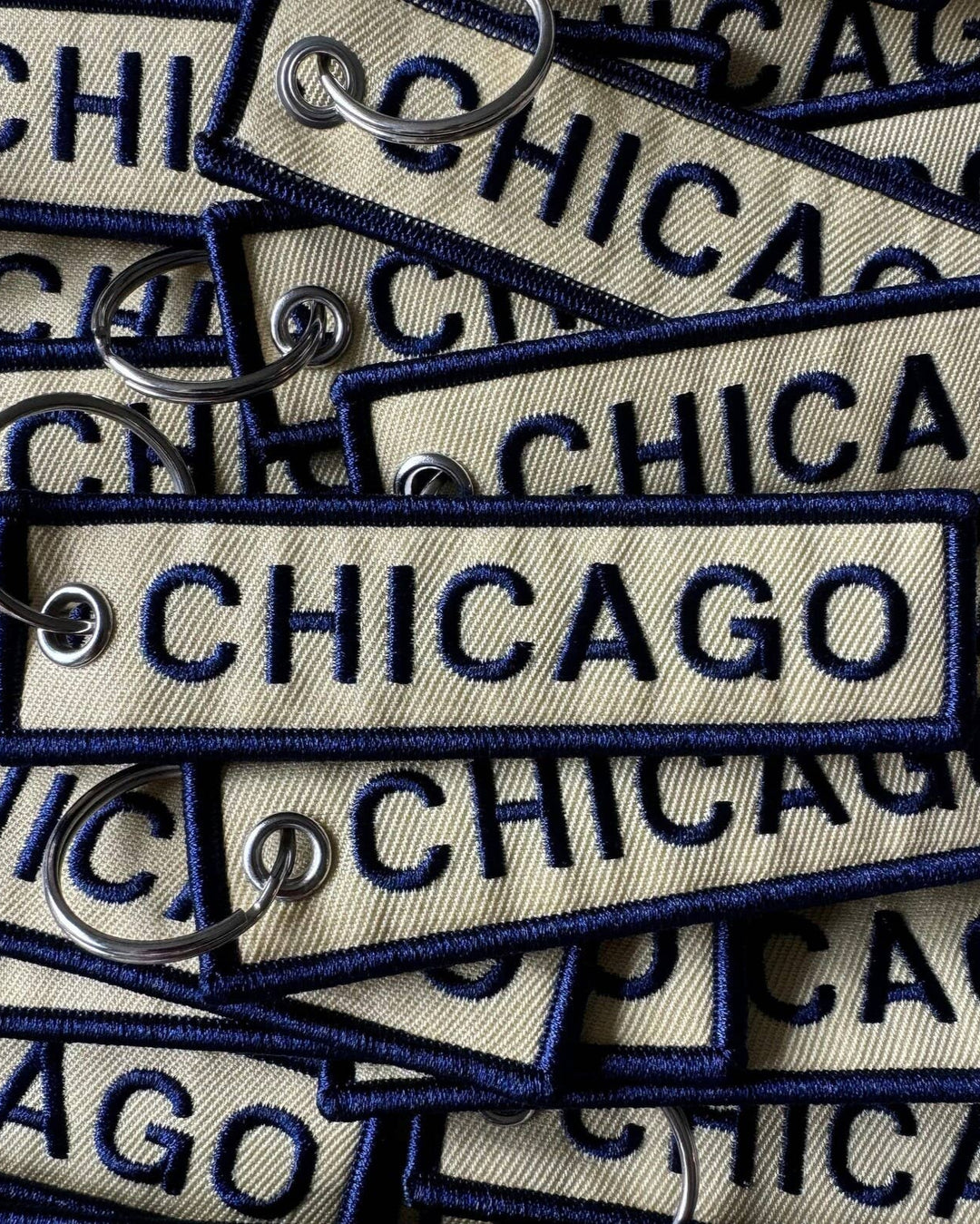 Collection of 'CHICAGO' embroidered tags on a beige background