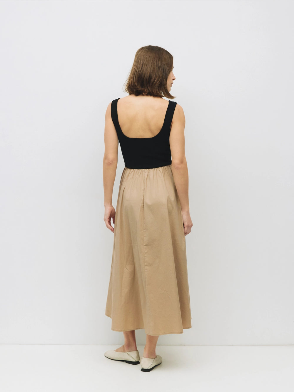 Woman wearing a black and beige cotton dress on a white background