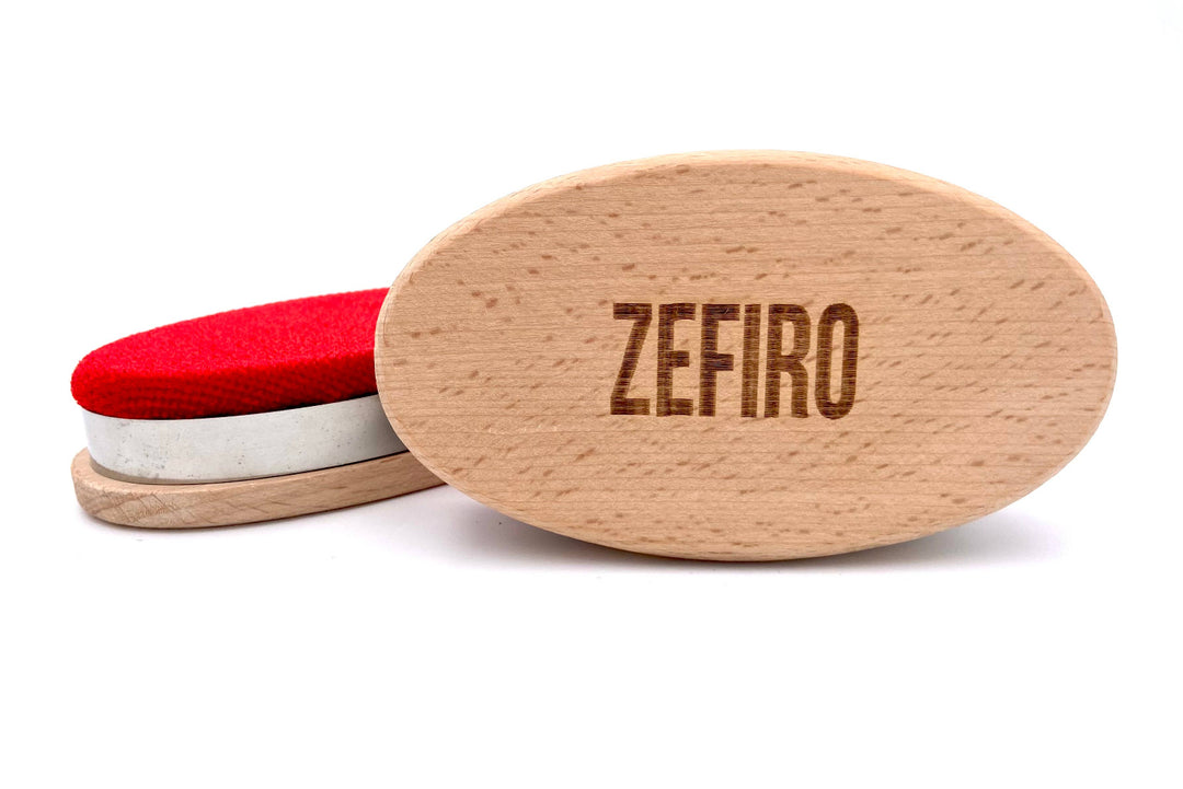 Wooden lint remover with red, metal, and brown sections on a white background