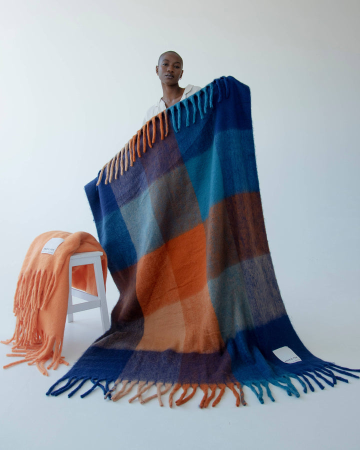 Colorful striped blanket with fringes on a white background