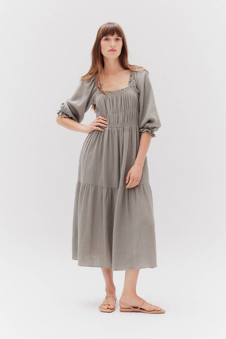 Woman wearing a muted green cotton dress sold at Winsome a cute boutique in chicago