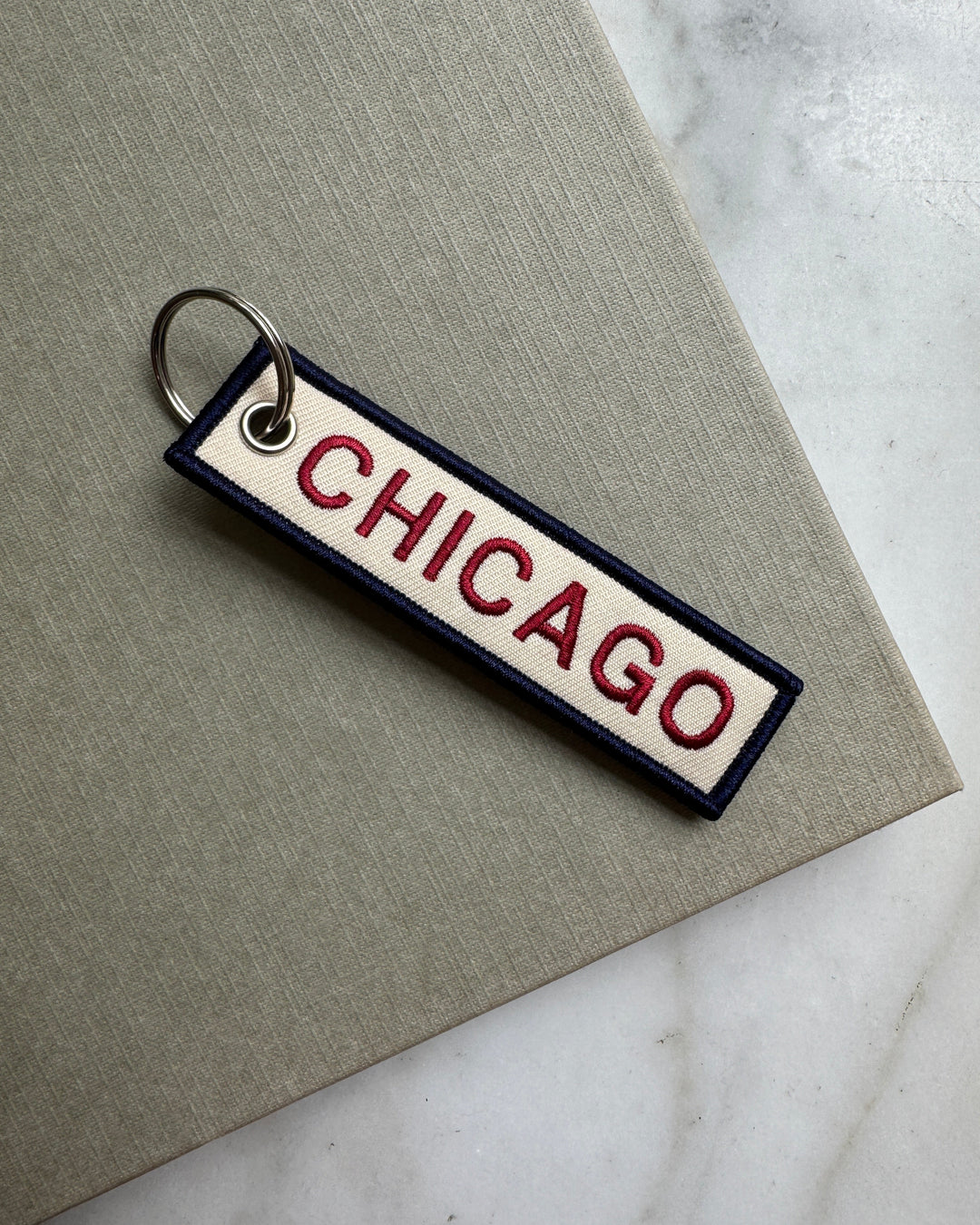 Keychain with 'Chicago' text on a marble surface