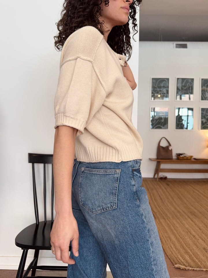 Woman wearing a beige sweater and blue jeans in a boutique in Avondale Chicago