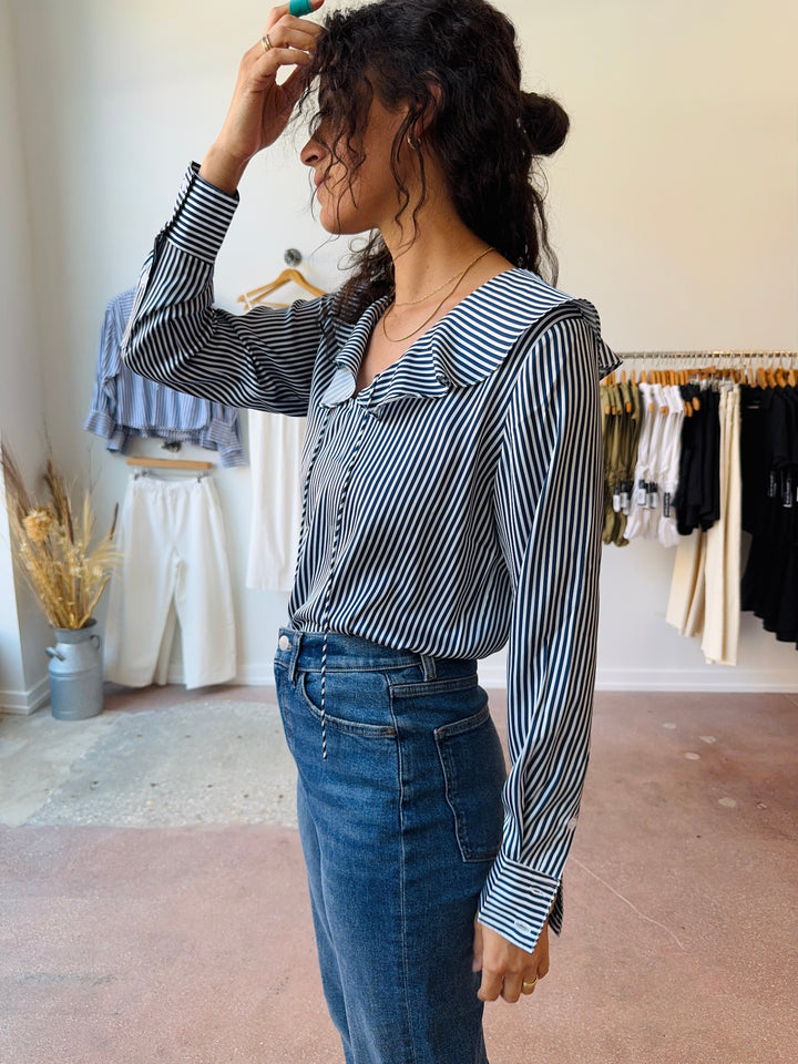 Woman wearing a navy and white striped shirt and jeans in a clothing store. Winsome clothing and goods chicago avondale logan square.