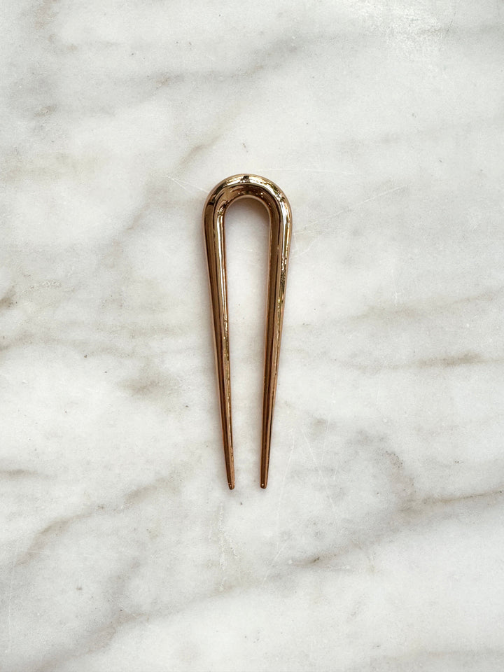 Gold hairpin on a marble surface