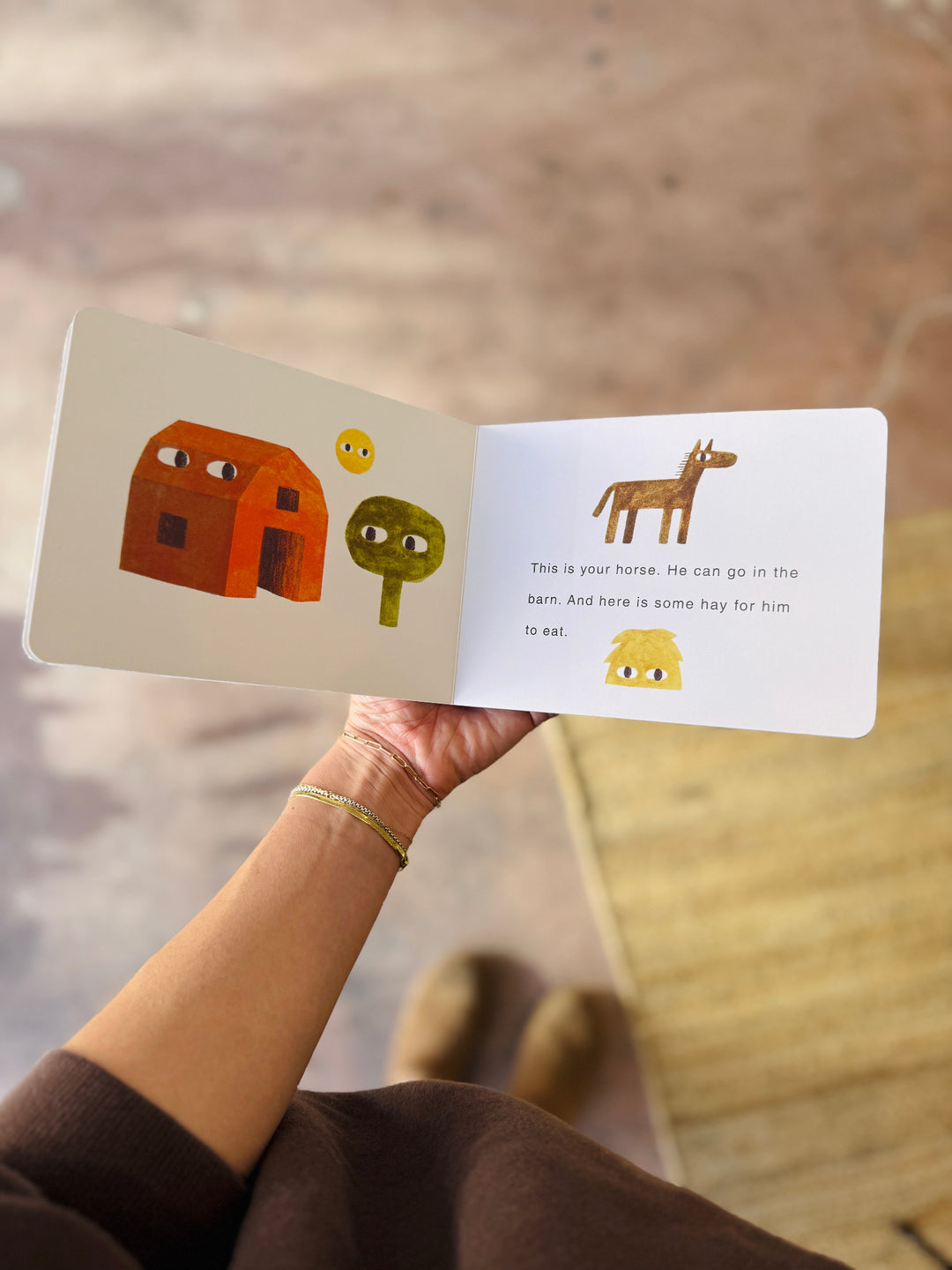 Children's book with illustrations of a house, tree, and horse held by a person.