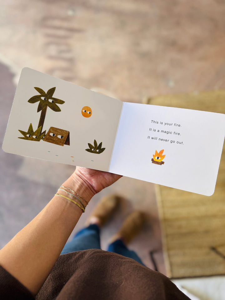 Person holding a jon klassen your island children's book with illustrations and text.